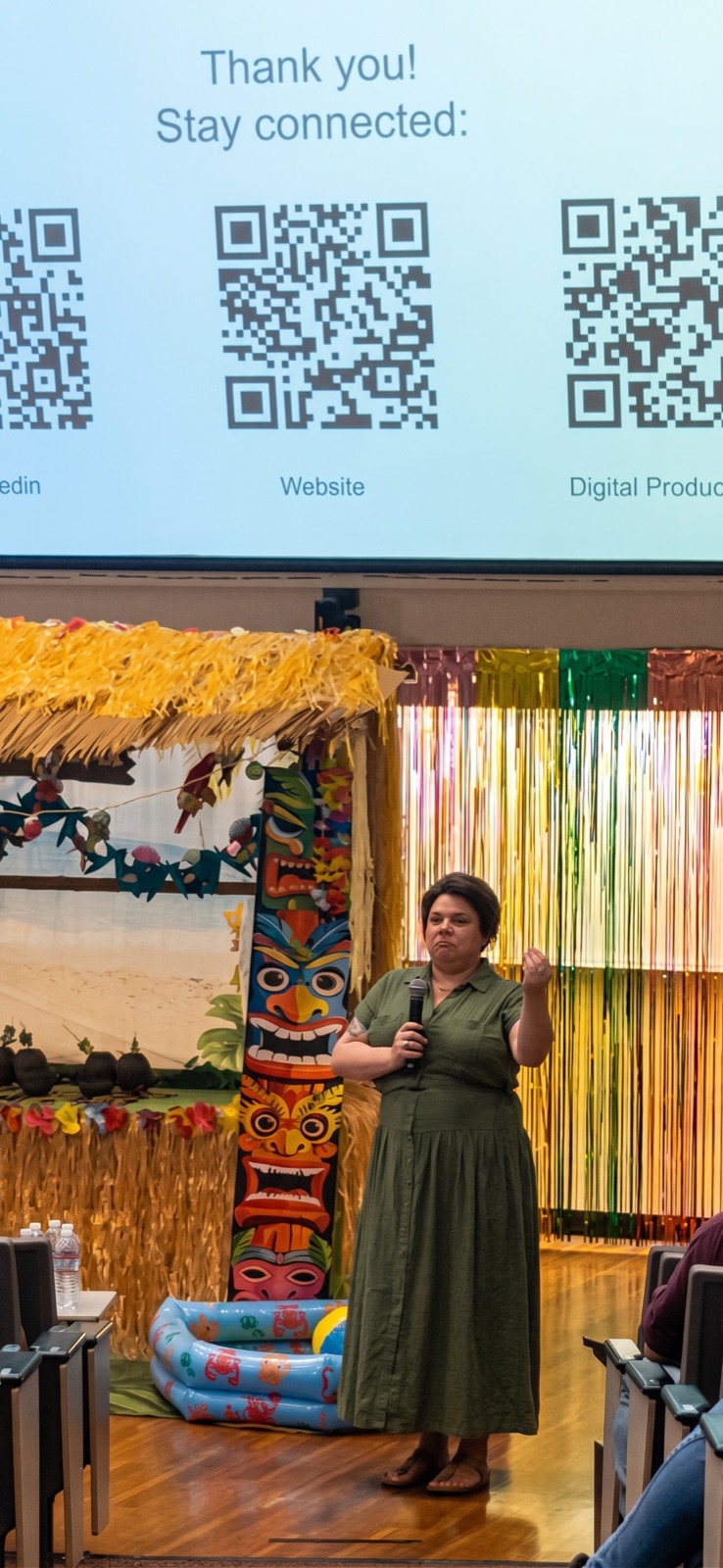 Dr. Victoria Verlezza on stage with a microphone, speaking to an audience